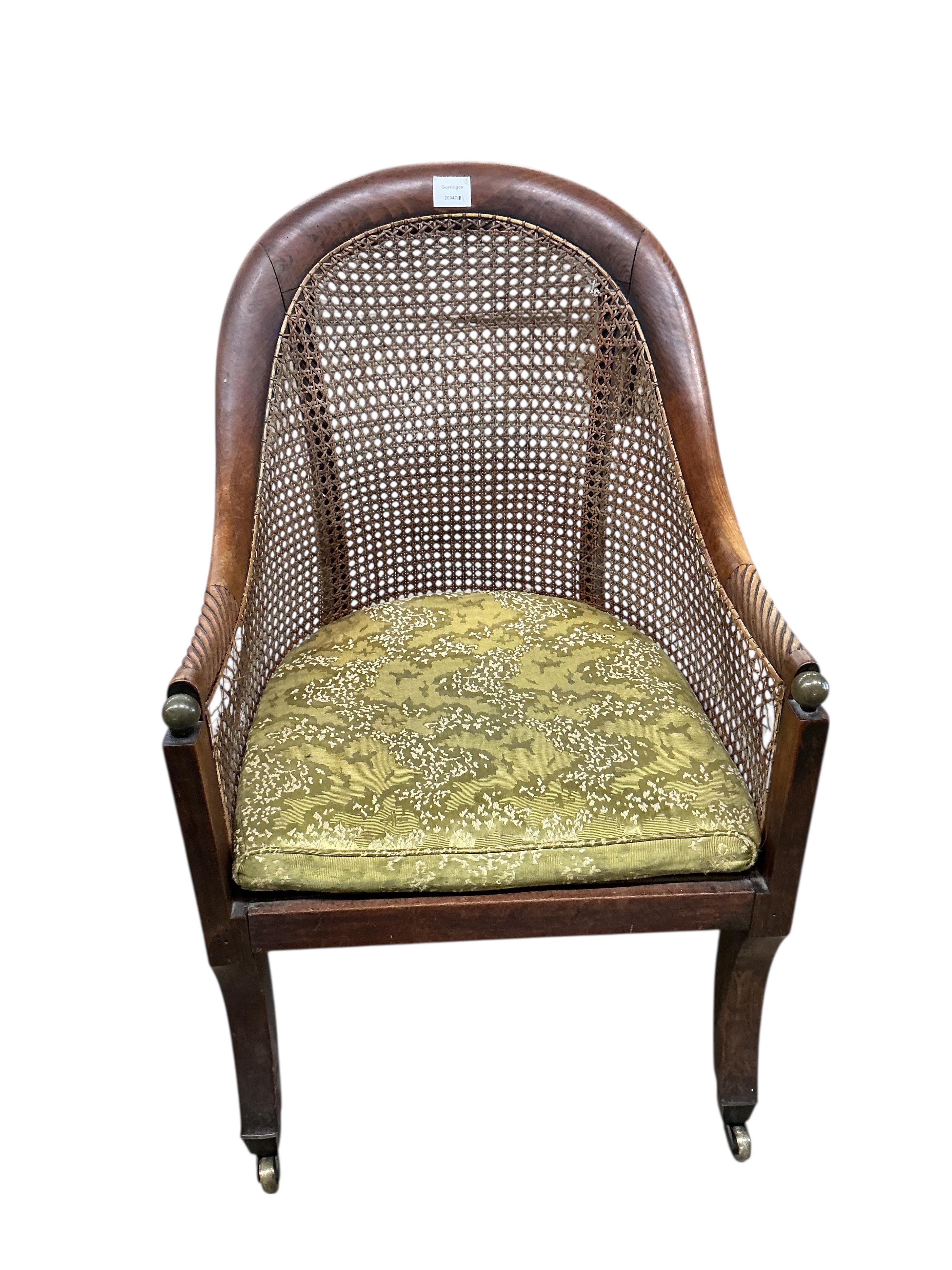 A Regency mahogany caned bergere armchair, (damaged cane) together with a Regency simulated rosewood and brass caned bergere armchair, larger width 49cm, depth 60cm, height 83cm